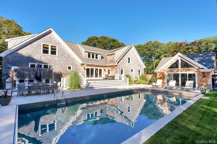 Outdoor pool with a patio area, an exterior structure, an outbuilding, and french doors