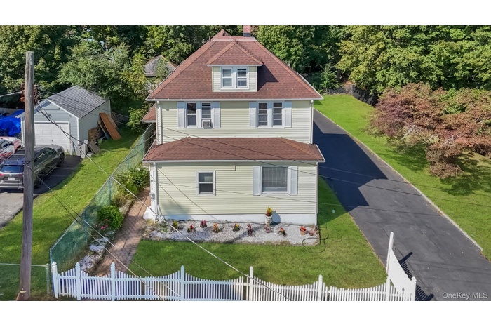 View of front of home featuring a shingled roof and a chimney
