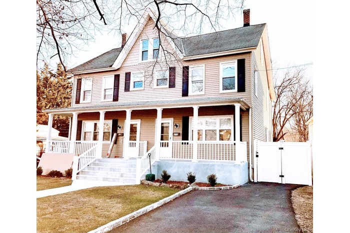 View of front of property, driveway and  gate to backyard
