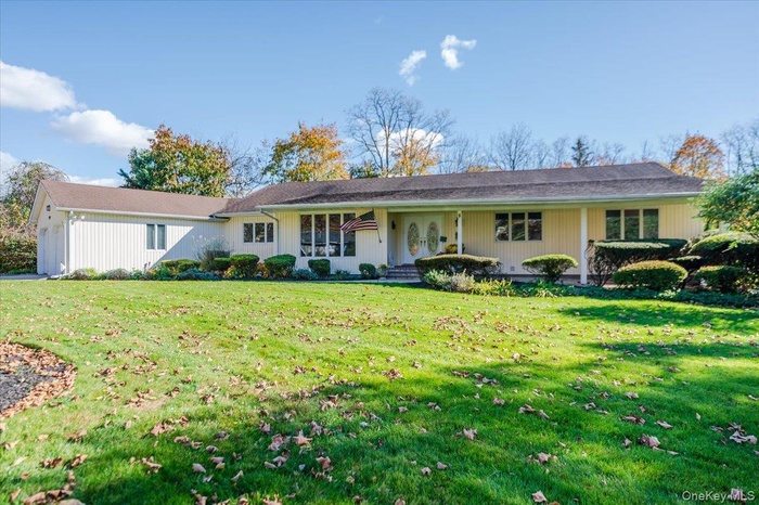 Ranch-style home with a porch and a front lawn