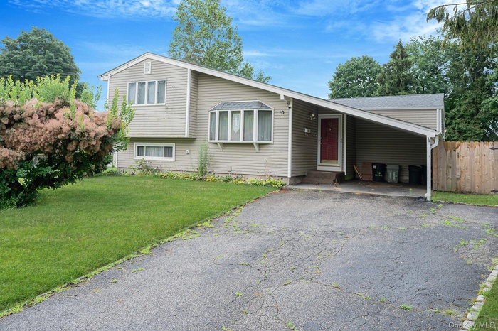 Split level home with driveway and an attached carport