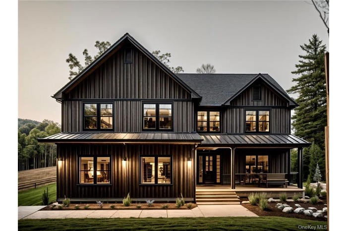 front view of house with a porch, board and batten siding, a lawn, a standing seam roof, and a metal roof.Photos of a previous build