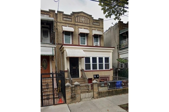 View of front facade with brick siding, a gate, and a fenced front yard