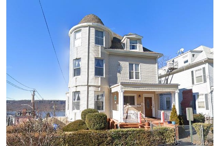 Victorian home with a porch and a gate