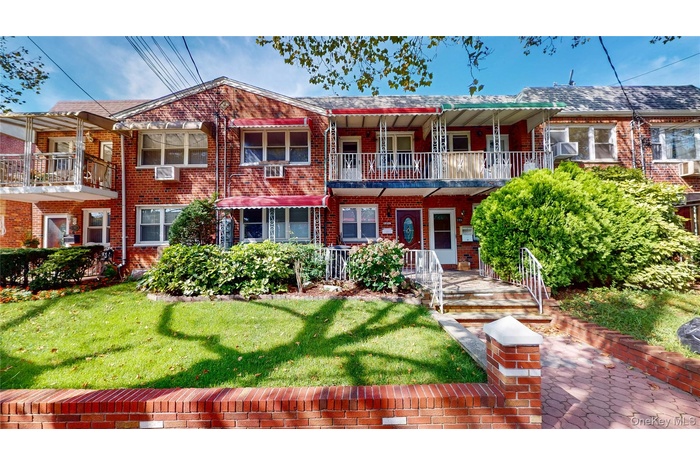 Traditional-style home with brick siding, a front lawn, and covered porch