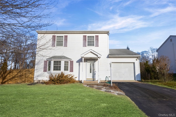 View of front of home with asphalt driveway, an attached garage, and roof with shingles