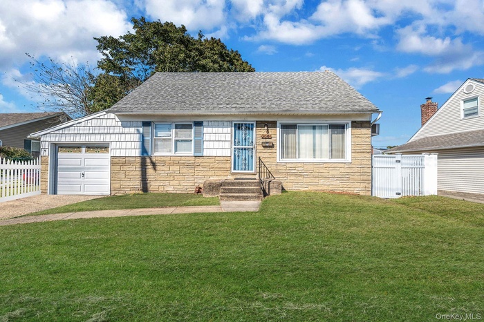 View of front of home with stone siding, a shingled roof, a garage, and driveway