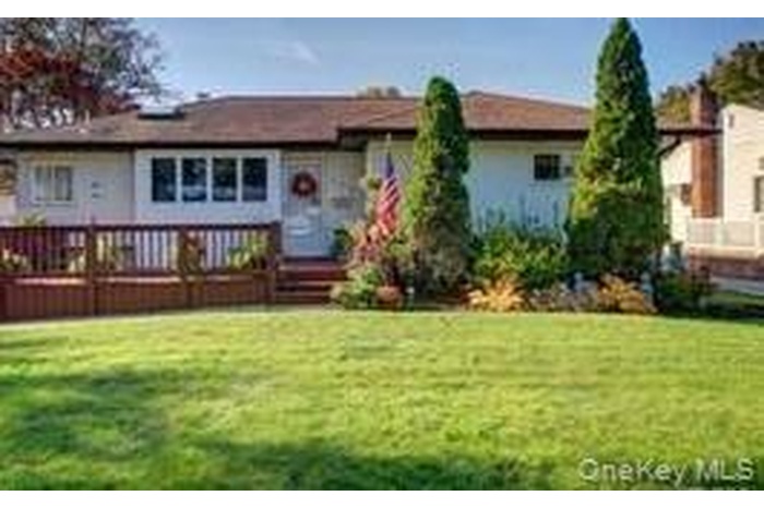View of front of house with a front lawn and a wooden deck