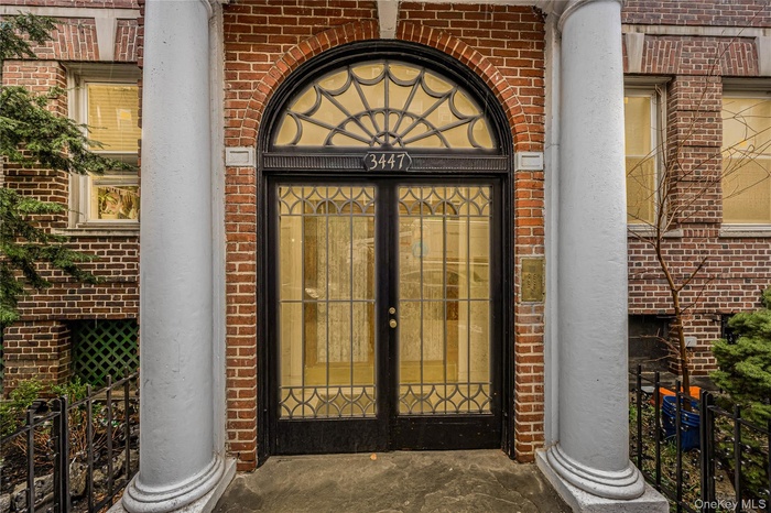 Property entrance with brick siding and fence