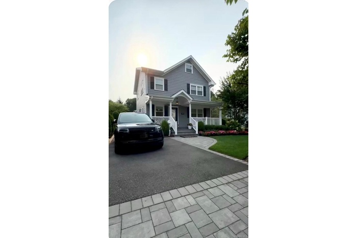 View of front facade with covered porch and asphalt driveway