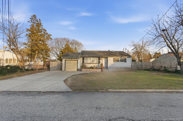 Single story home with concrete driveway and an attached garage