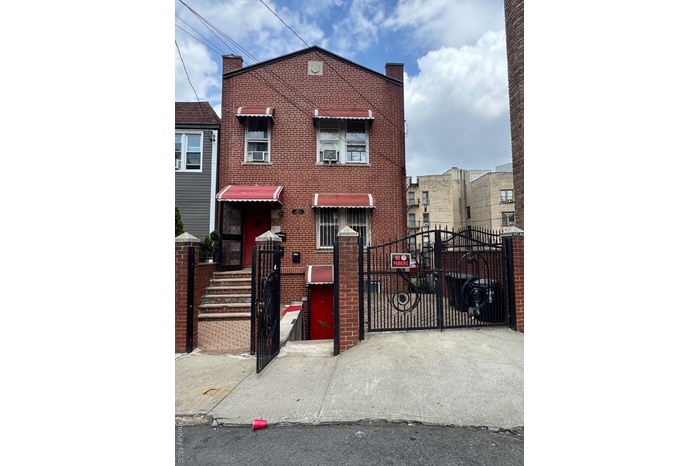 Traditional home featuring a gate and brick siding
