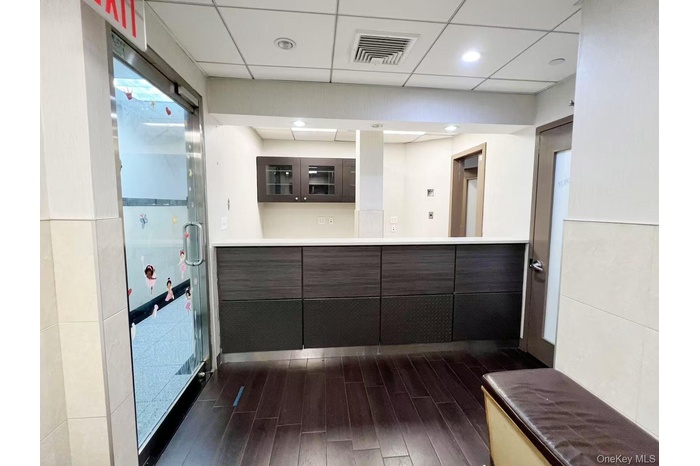 Bathroom featuring visible vents, a shower stall, a drop ceiling, wood finished floors, and vanity