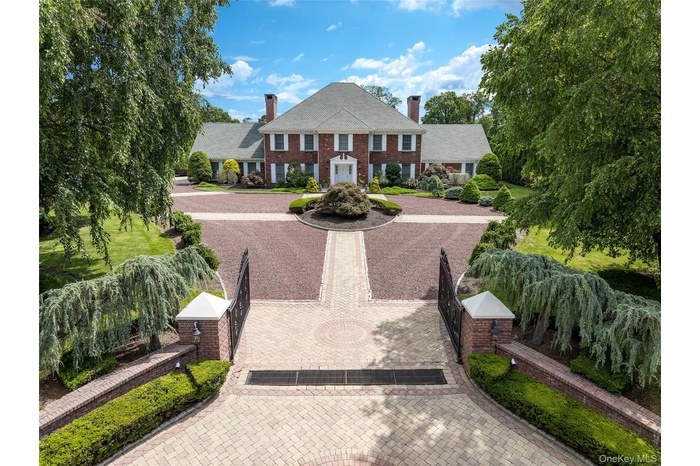 Iconic Georgian Colonial in the Murray Hill Estate Section in Scarsdale features circular 3-tone driveway, classic details, two chimneys, brick siding