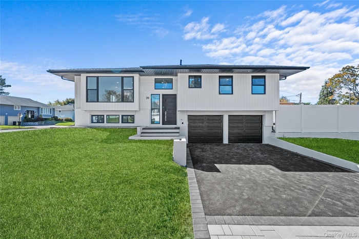 View of front facade with decorative driveway and a garage