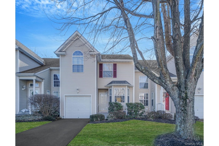Front of unit with driveway and 1 car garage.