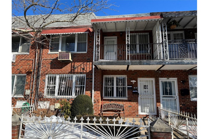 View of front facade featuring brick siding and a balcony