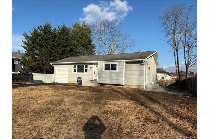 Back of property with roof with shingles and a garage