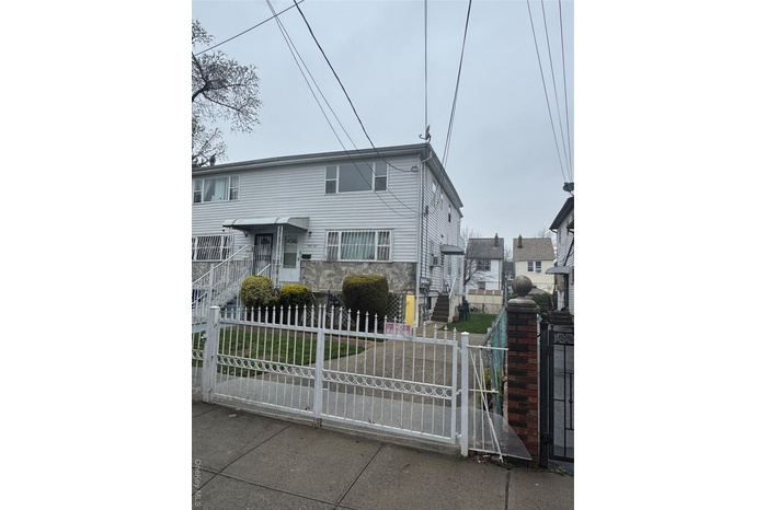 View of property featuring a gate and a fenced front yard
