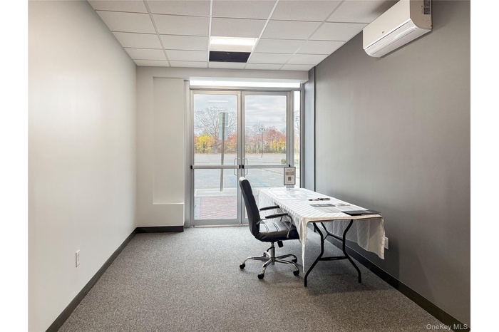 Office with a paneled ceiling and a wall mounted air conditioner