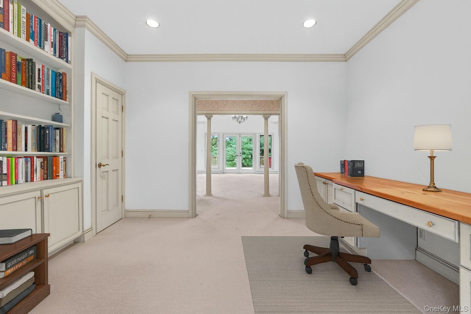 Virtually Staged Office area with built in study area, light carpet, french doors, ornamental molding, and recessed lighting