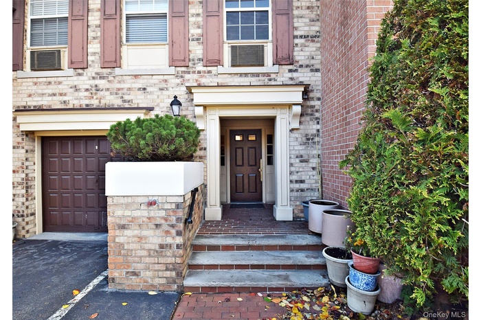 Doorway to property with brick siding and driveway