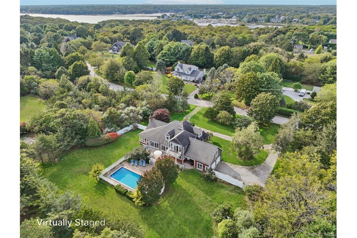 A captivating aerial perspective showcasing the property’s rear elevation, where architecture and landscape blend in perfect harmony. Virtually Staged