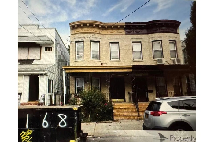 View of front of home featuring covered porch and brick siding