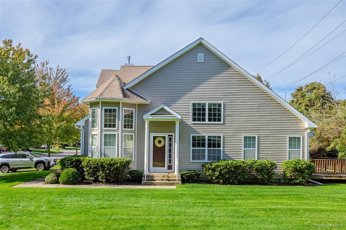 View of front of home featuring a front yard and roof with shingles