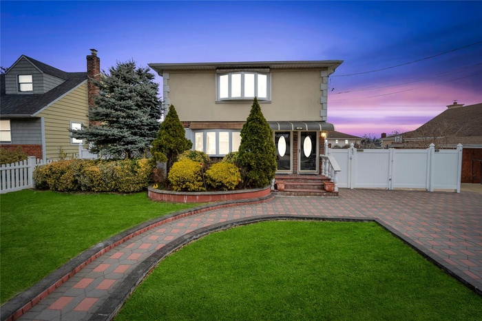 Rear view of house featuring a gate, fence, a yard, stucco siding, and a patio area