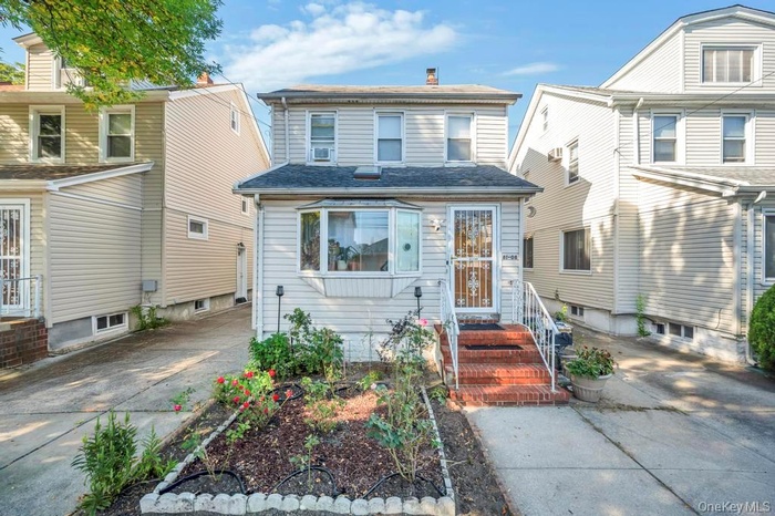 View of front of home featuring a chimney and roof with shingles