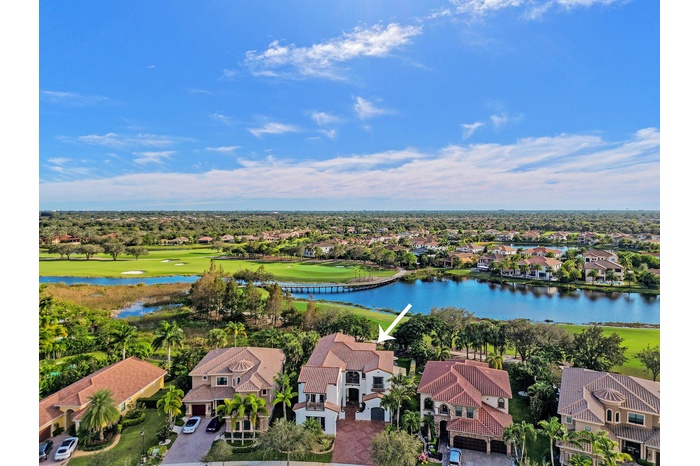 Expansive views overlooking the lake and golf course, with a charming bridge adding to the picturesque scenery.