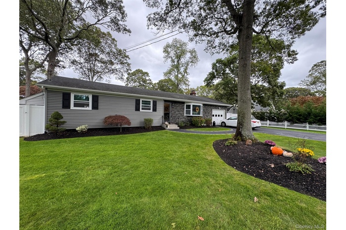 Ranch-style house with a chimney and asphalt driveway