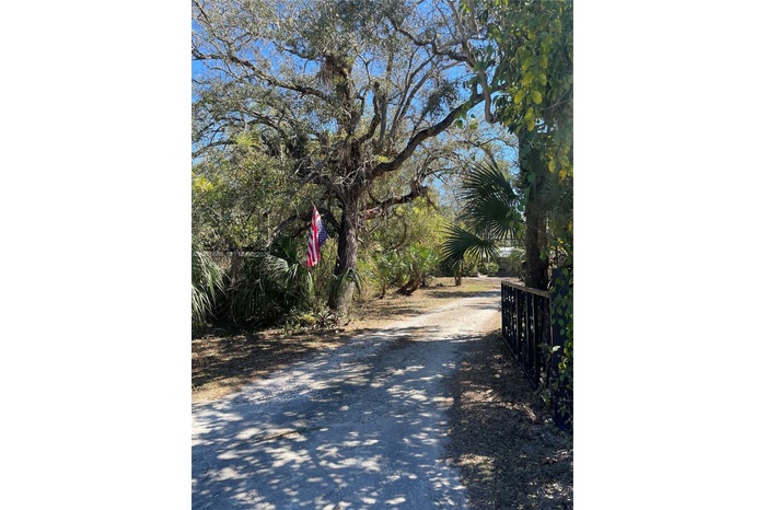 INVITING AND ENCHANTING ENTRY WAY WITH CUSTOM BUILT IRON GATE