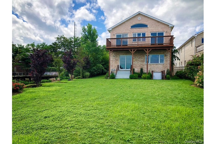 Rear view of house with brick siding and a yard