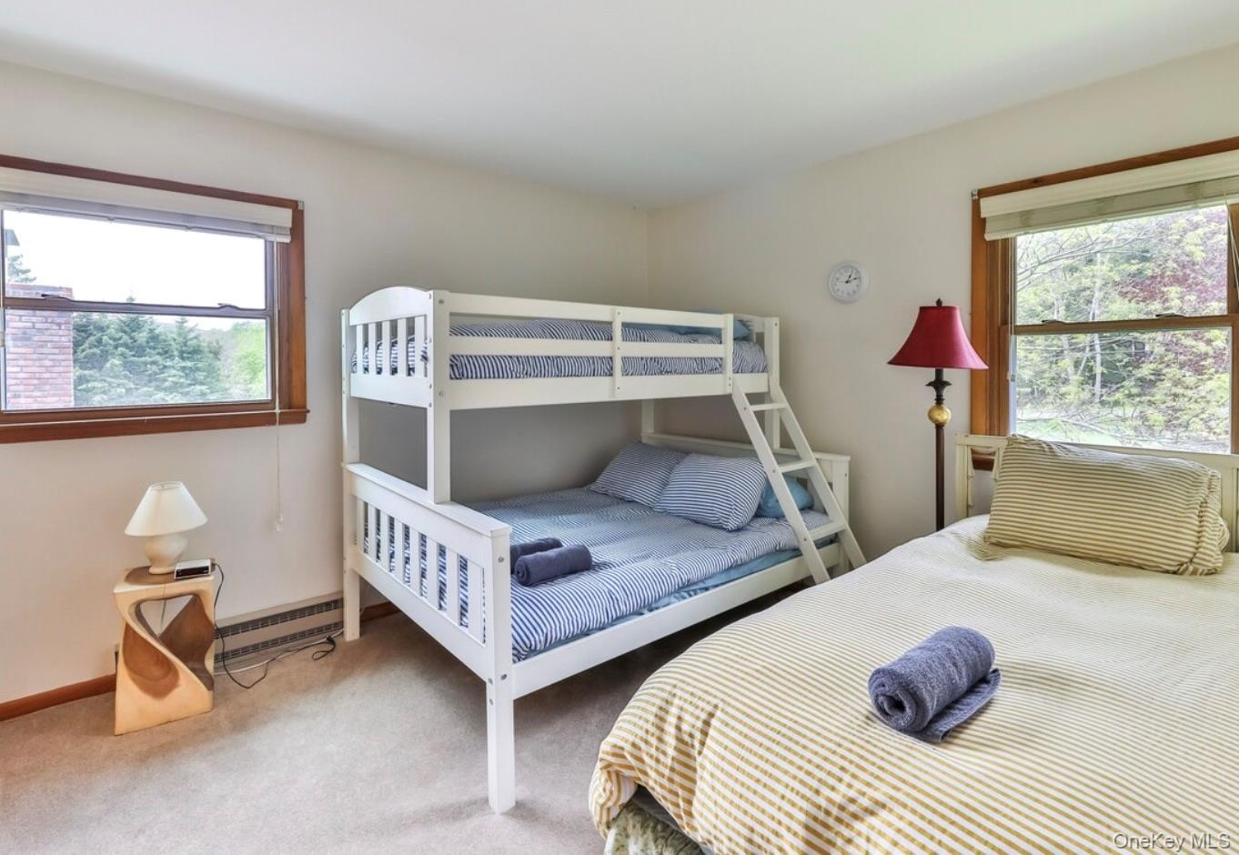 Carpeted bedroom featuring baseboard heating and baseboards