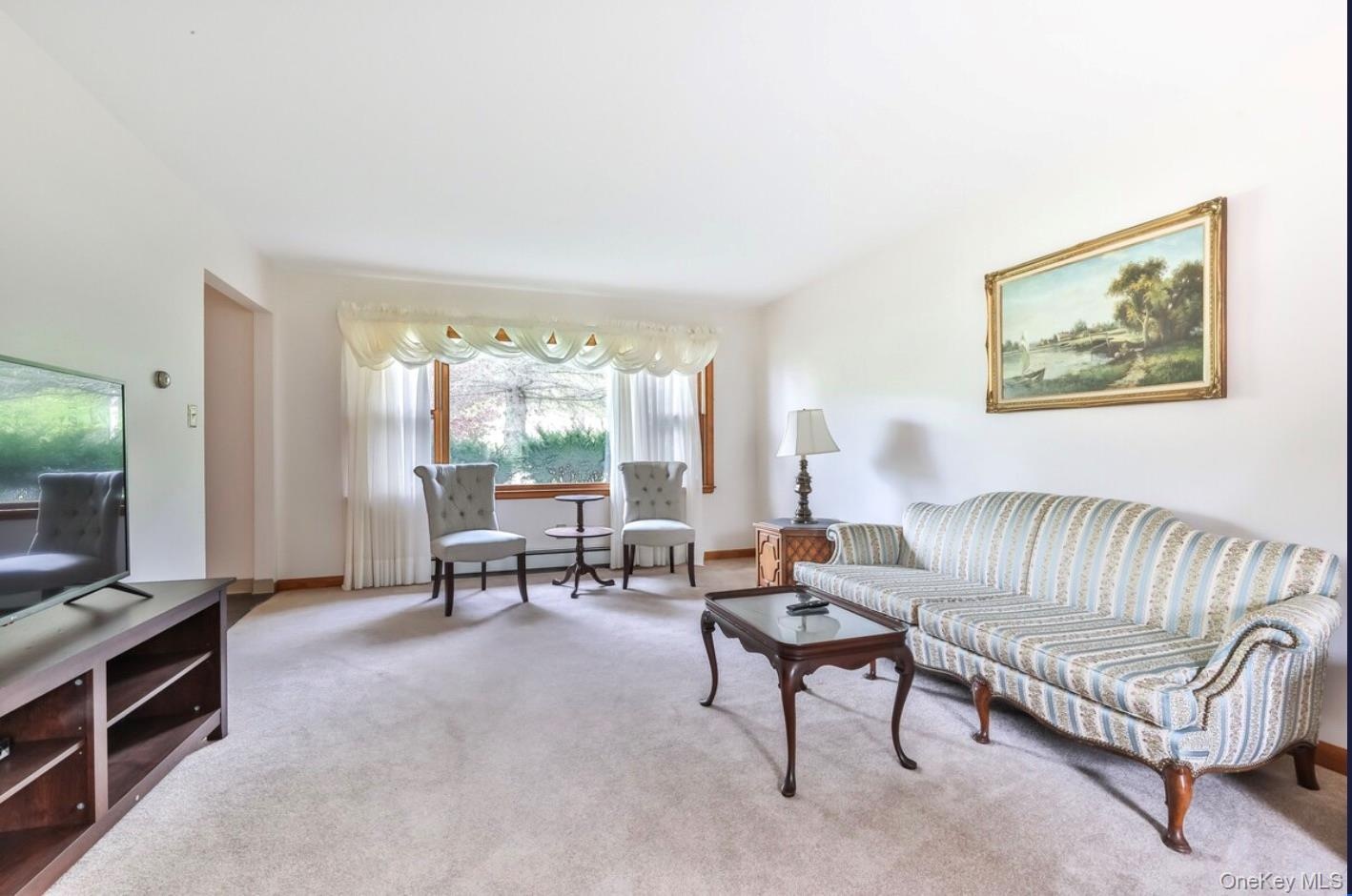 Carpeted living area featuring baseboards