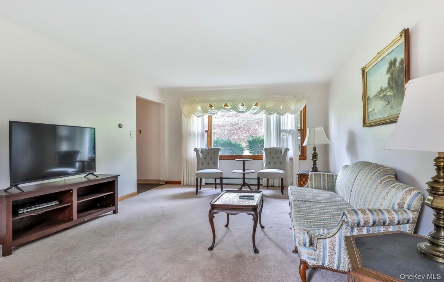 Carpeted living area featuring baseboards