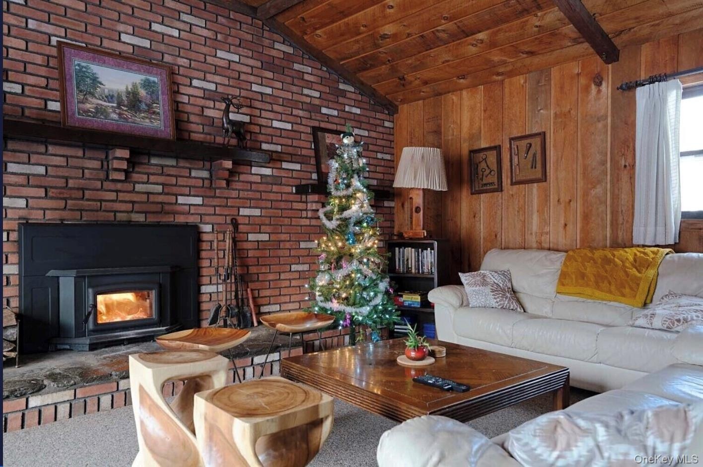 Carpeted living area featuring wooden ceiling and wood walls