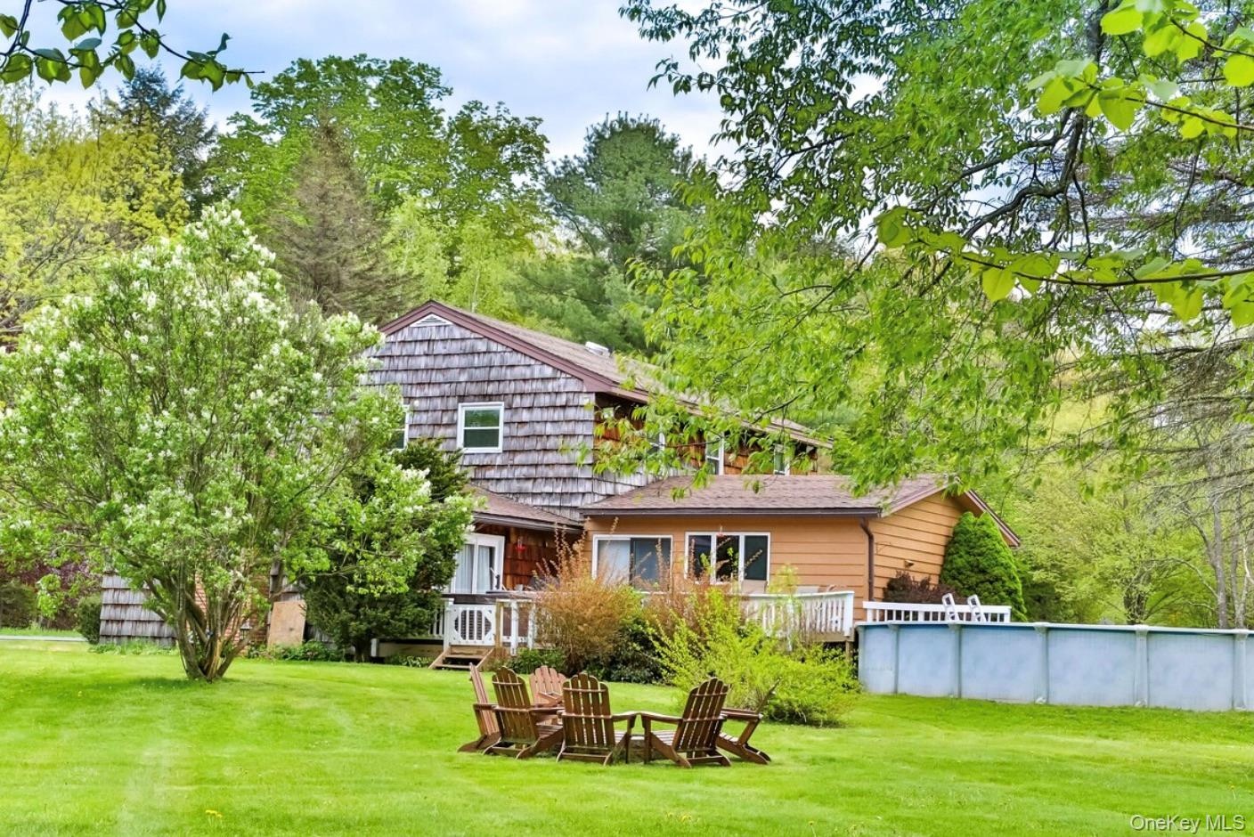 Rear view of property featuring a yard and an outdoor pool