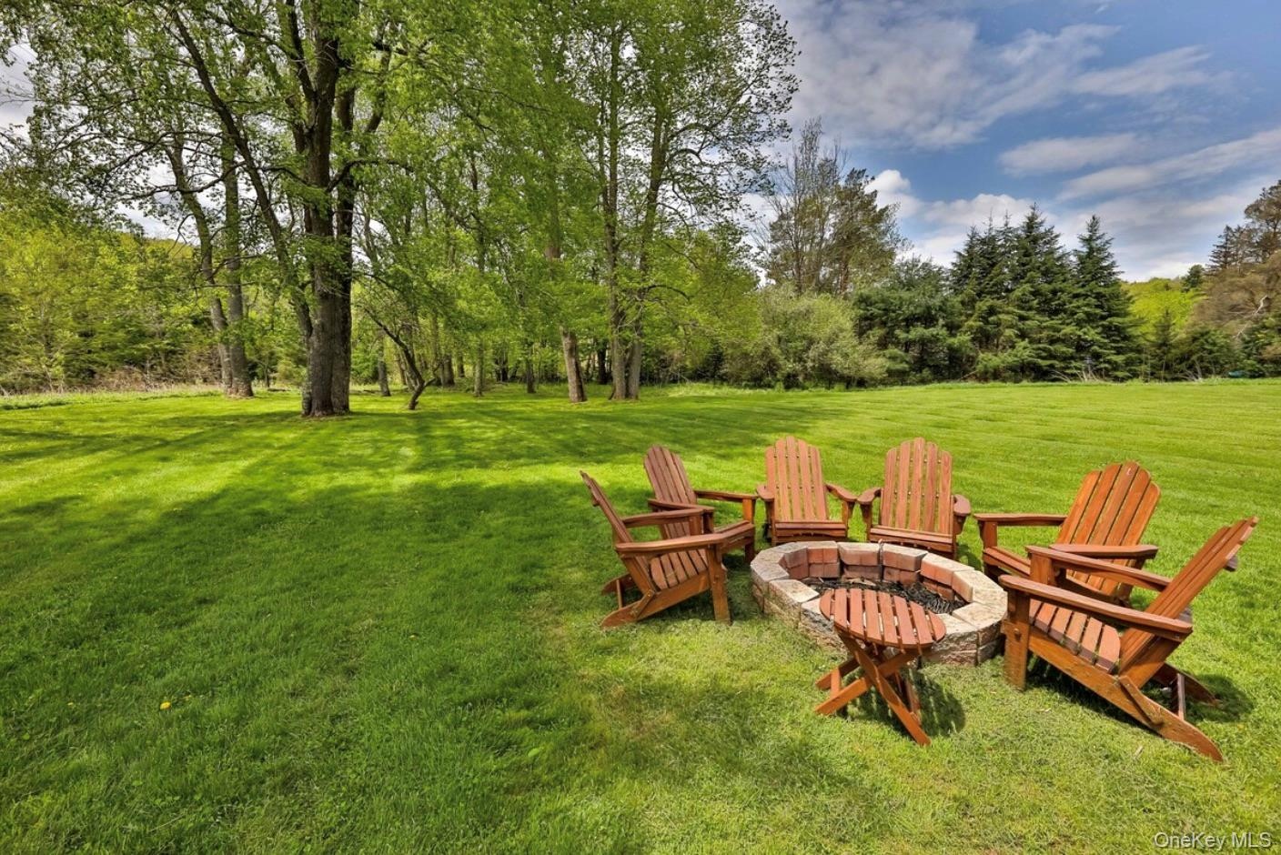 View of grassy yard featuring a fire pit
