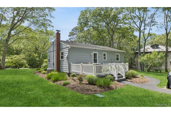 Rear view of house featuring a chimney, a yard, a wooden deck, and cooling unit