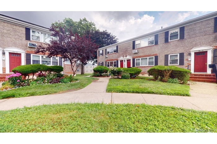 View of front of house with a front yard, brick siding, and crawl space
