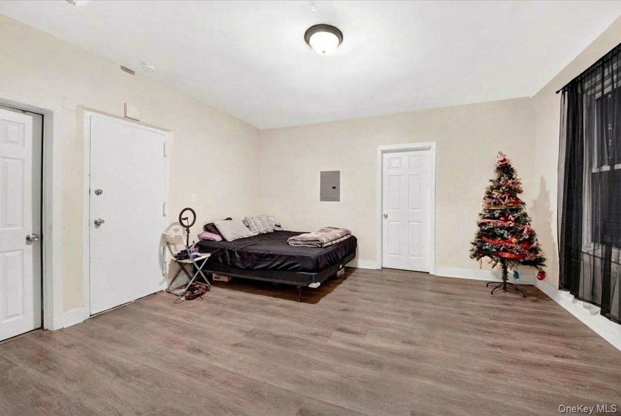 Bedroom featuring light wood-style floors and electric panel