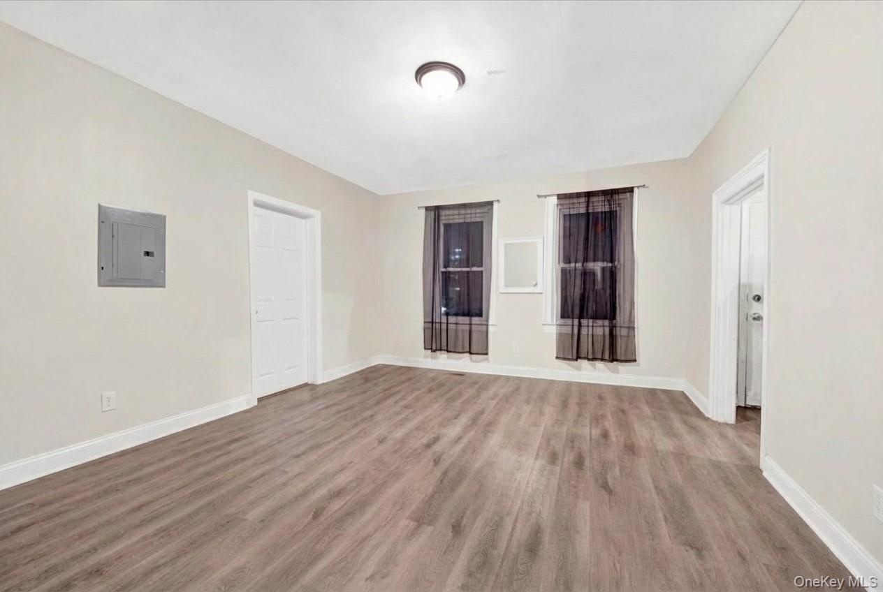 Unfurnished room featuring electric panel and light wood finished floors
