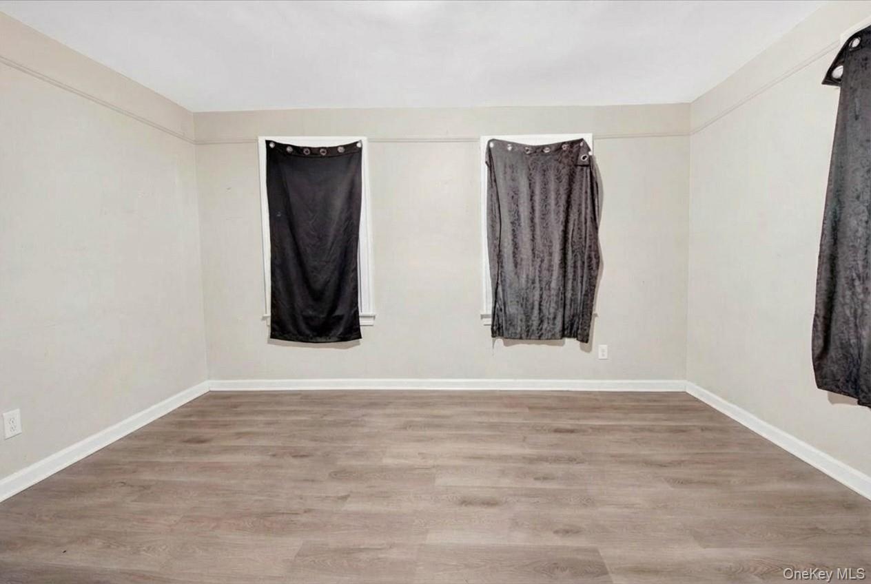 Unfurnished room with light wood-style flooring and baseboards