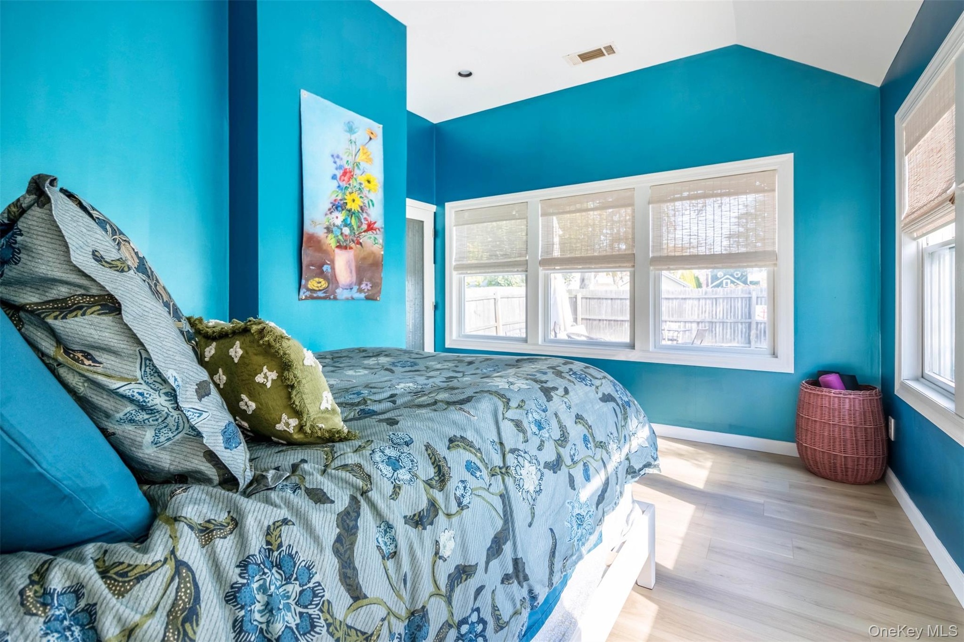 Bedroom featuring multiple windows, wood finished floors, and vaulted ceiling