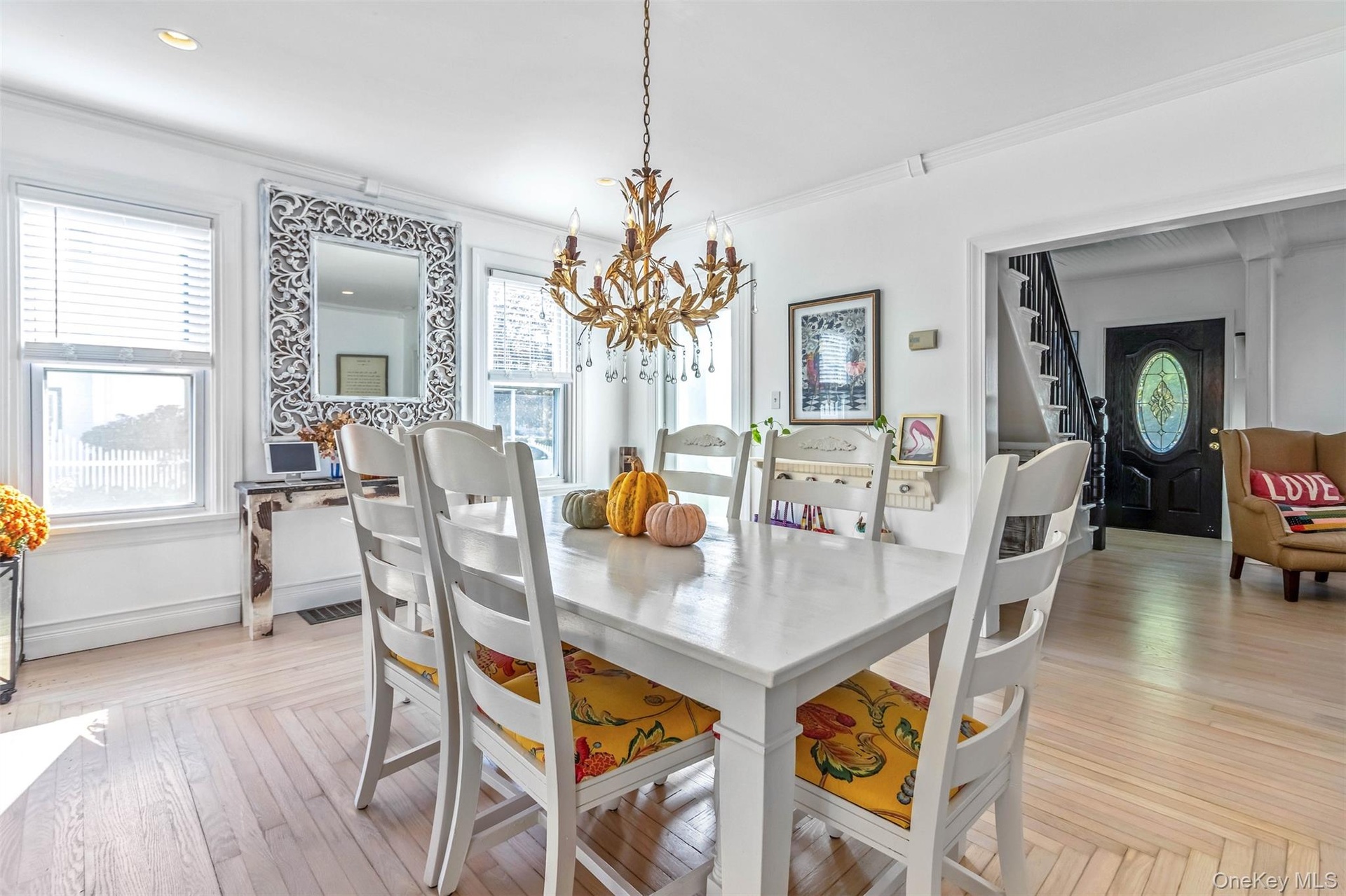 Dining space with a chandelier, ornamental molding, parquet flooring, and stairs