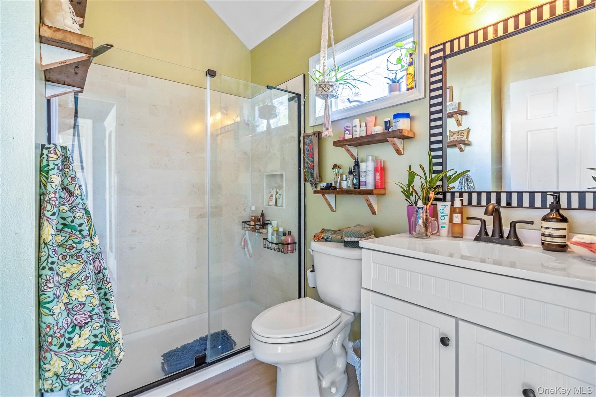 Full bathroom with a shower stall, vanity, and light wood-style flooring