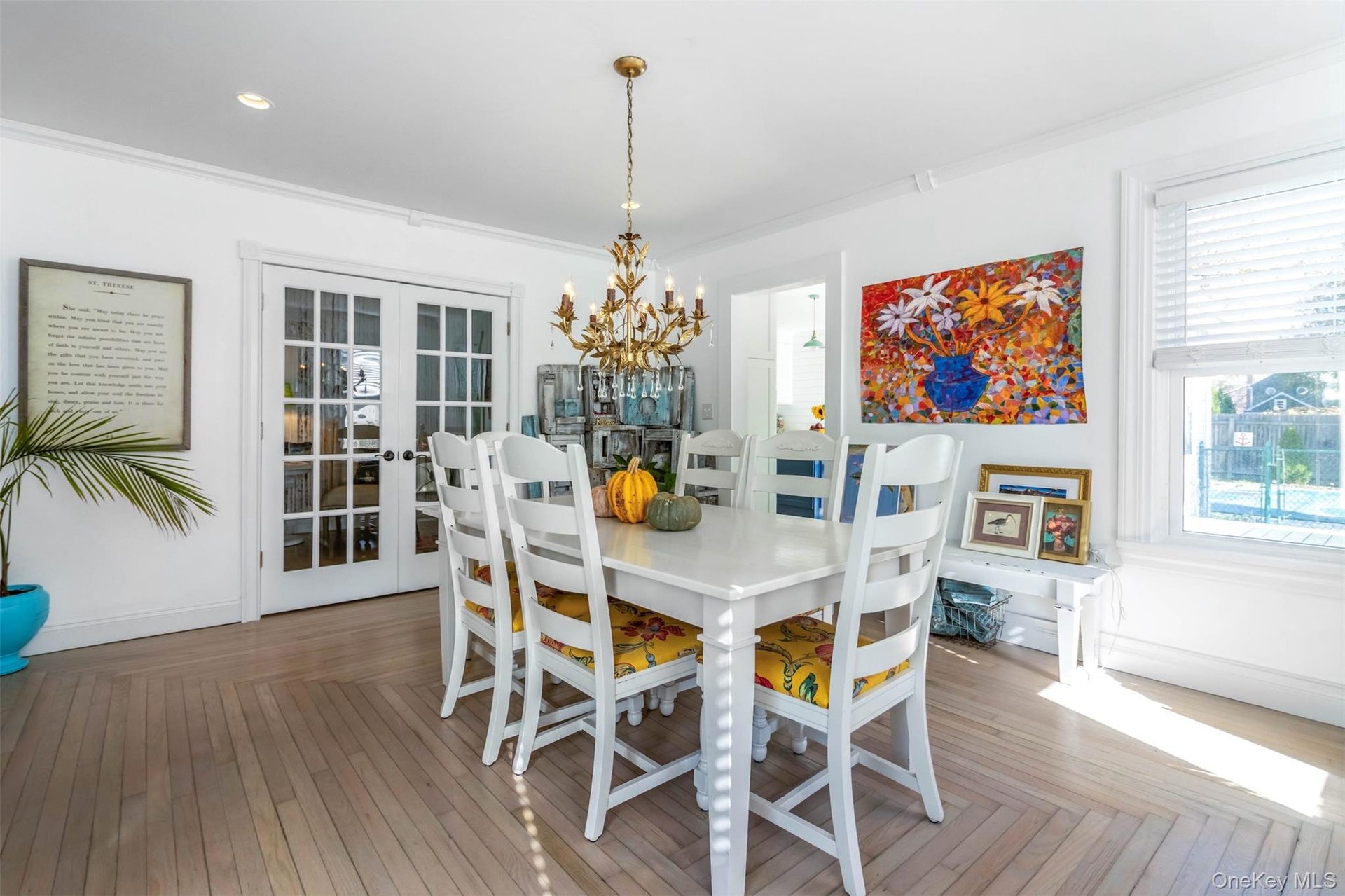 Dining area with french doors, a chandelier, ornamental molding, and wood finished floors